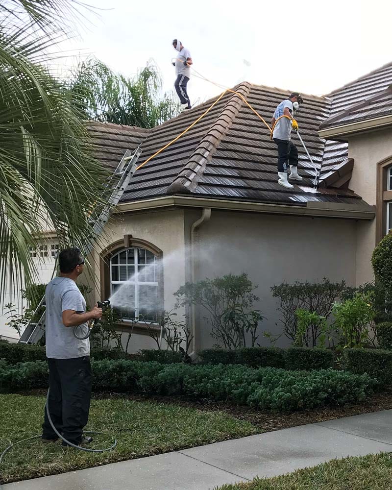 3 men pressure washing roof