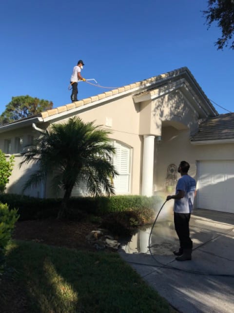 Guy cleaning roof, guy spraying driveway