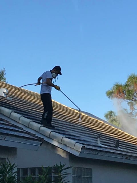 Guy power washing roof