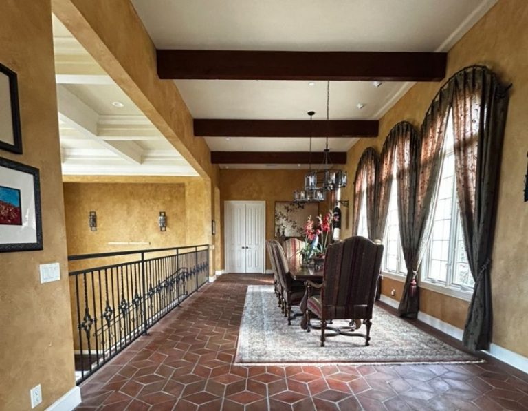 Interior dining room with warm gold textured walls and dark wood ceiling beams painted by Ultimate Services Co. in Sarasota