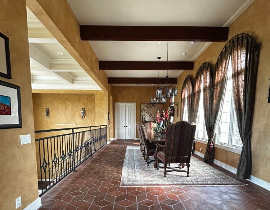 Interior dining room with warm gold textured walls and dark wood ceiling beams painted by Ultimate Services Co. in Sarasota