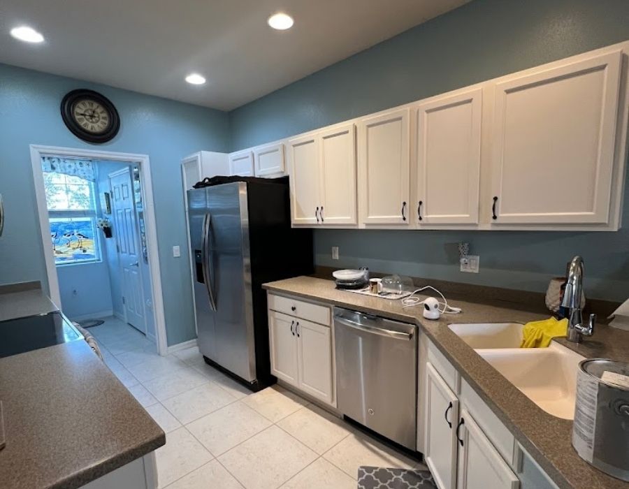 Freshly painted white kitchen cabinets and soft blue interior walls in a Sarasota Florida home by Ultimate Services Co.